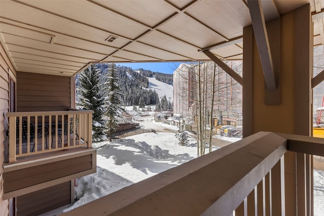 snow covered deck with a mountain view