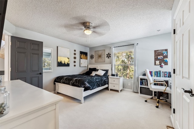 bedroom featuring light carpet, ceiling fan, and a textured ceiling