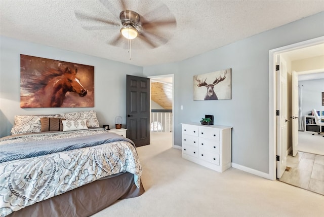 bedroom with a textured ceiling, carpet floors, ceiling fan, and baseboards