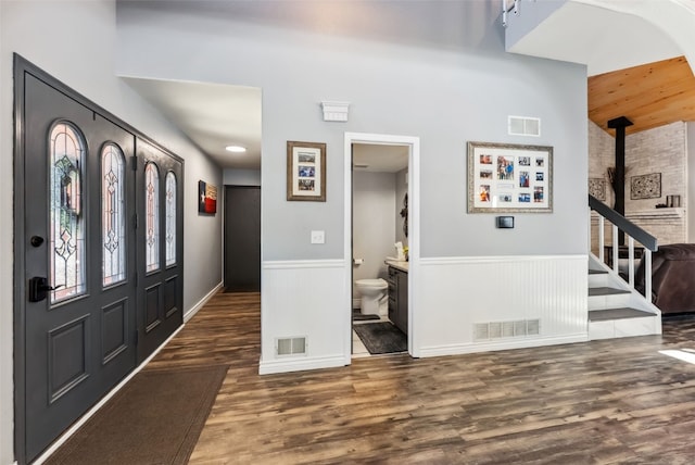 foyer with visible vents, wood finished floors, and wainscoting