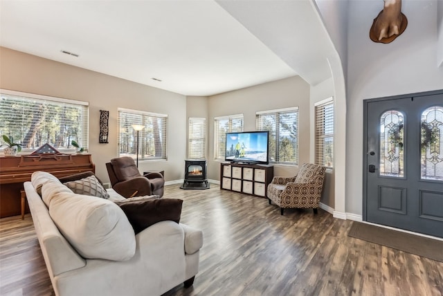 foyer with a wood stove, baseboards, and wood finished floors