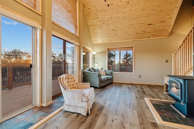 interior space with wood-type flooring, a wood stove, high vaulted ceiling, and wooden ceiling