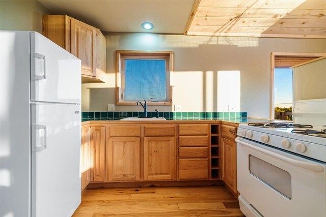 kitchen with tile counters, sink, light hardwood / wood-style floors, white appliances, and wood ceiling