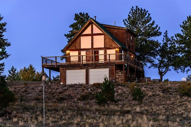 back of property featuring a garage and a deck