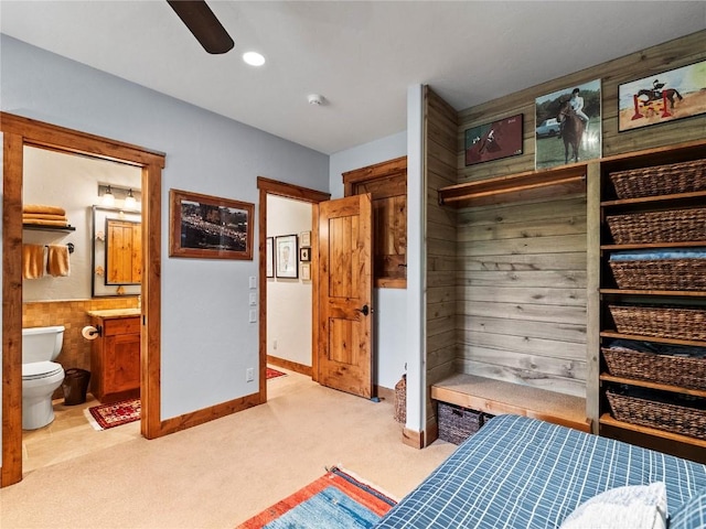 mudroom with light carpet, ceiling fan, and wood walls