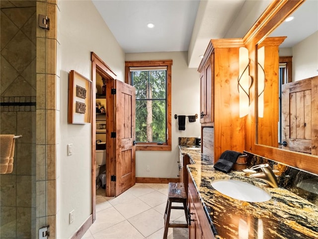 bathroom featuring tile patterned flooring, vanity, toilet, and a shower with door