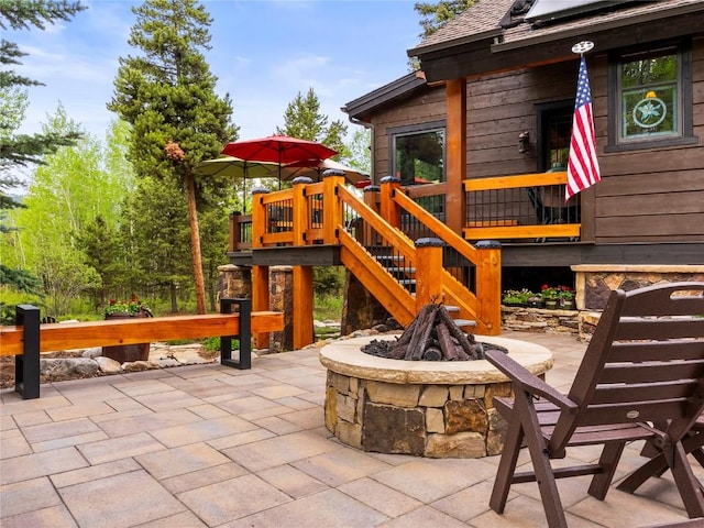 view of patio featuring a fire pit and a wooden deck