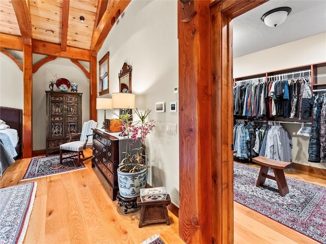 bedroom with vaulted ceiling with beams, wooden ceiling, light hardwood / wood-style flooring, and a closet