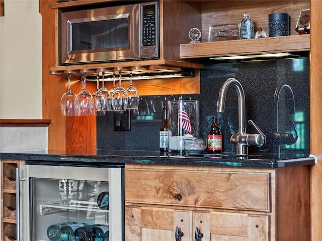 bar with stainless steel microwave, backsplash, and wine cooler