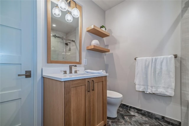 bathroom with vanity, a shower with shower door, and toilet