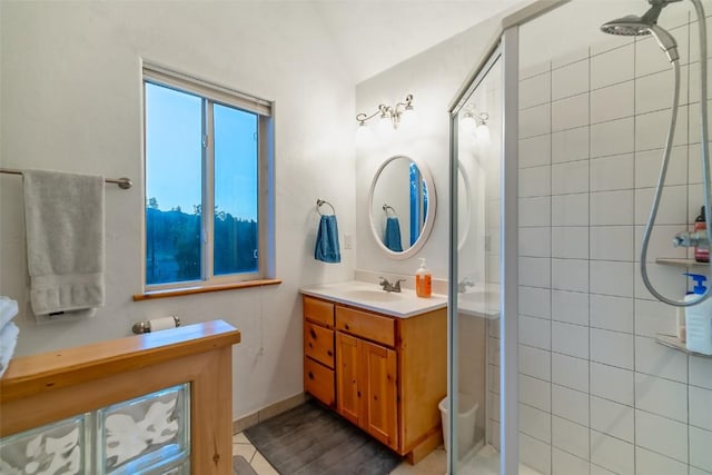 bathroom with a tile shower and vanity