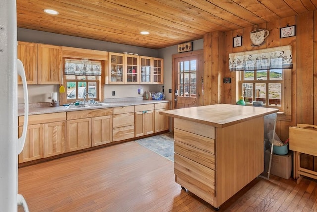 kitchen featuring light brown cabinets, sink, white fridge, light hardwood / wood-style floors, and wood ceiling