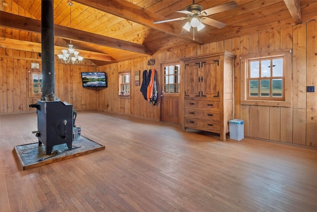 exercise area with a wood stove, a chandelier, hardwood / wood-style floors, and wood ceiling