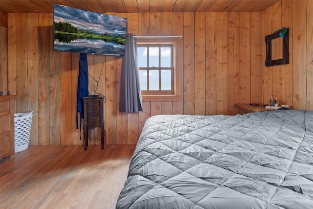 bedroom featuring hardwood / wood-style floors, wood walls, and wooden ceiling