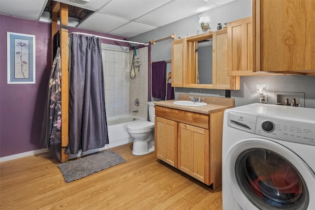 clothes washing area with sink, washer / clothes dryer, and light hardwood / wood-style flooring