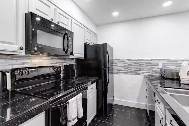 kitchen featuring dark tile patterned flooring, white cabinetry, and black appliances