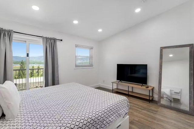 bedroom featuring hardwood / wood-style flooring, access to exterior, and vaulted ceiling