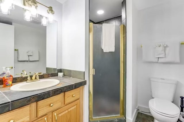 bathroom featuring toilet, an enclosed shower, and vanity