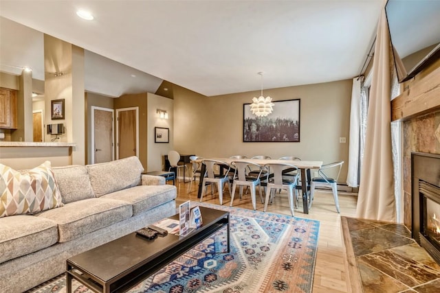 living area featuring a tiled fireplace, recessed lighting, and wood finished floors