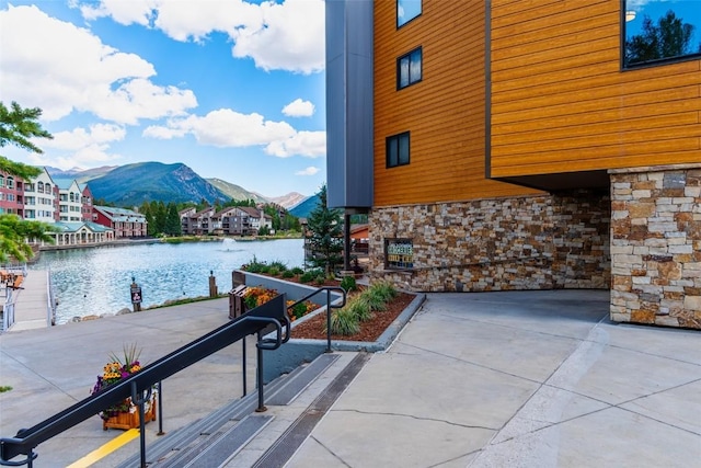 view of patio / terrace featuring a water and mountain view