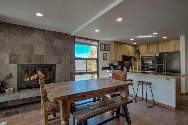 dining room featuring hardwood / wood-style flooring and a fireplace