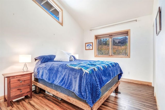 bedroom featuring vaulted ceiling, baseboards, and wood finished floors