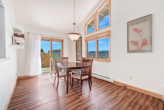 dining area with a baseboard heating unit, baseboards, and wood finished floors