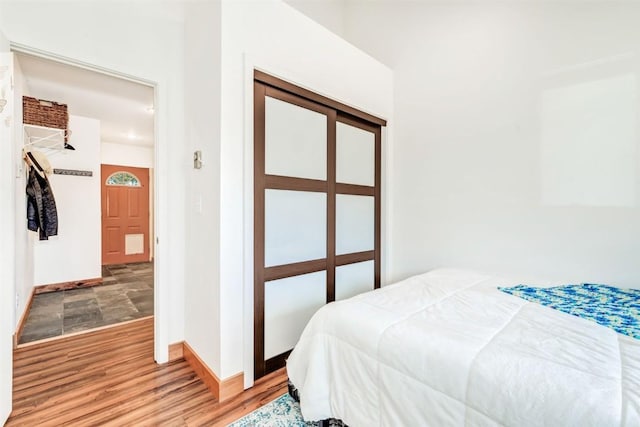 bedroom featuring baseboards and wood finished floors