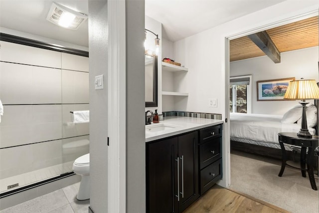 bathroom featuring beam ceiling, wood-type flooring, toilet, vanity, and a shower with shower door