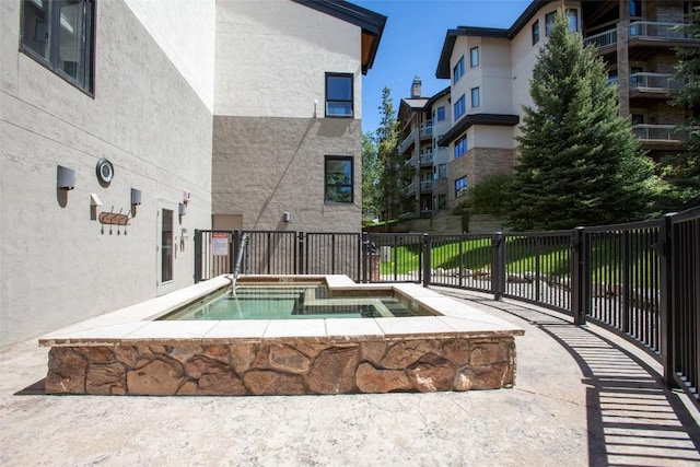 view of pool with a hot tub