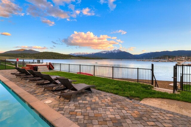 view of swimming pool featuring a patio and a water and mountain view