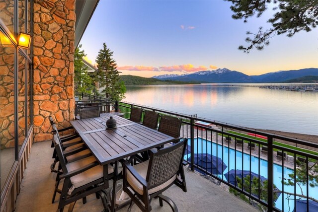 balcony at dusk with a water and mountain view