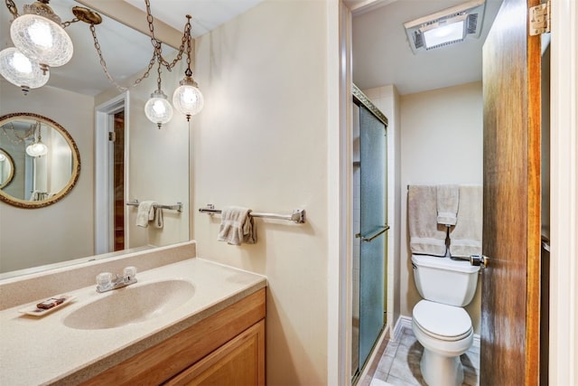 bathroom featuring tile patterned flooring, vanity, a shower with shower door, and toilet