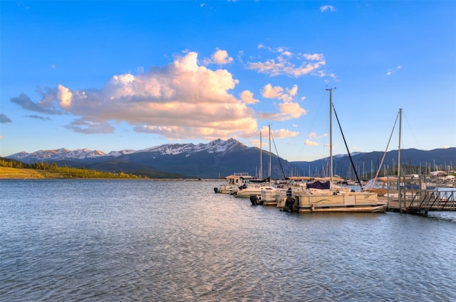 water view with a mountain view and a dock