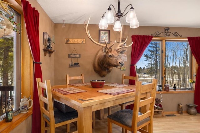 dining space featuring hardwood / wood-style flooring and a notable chandelier