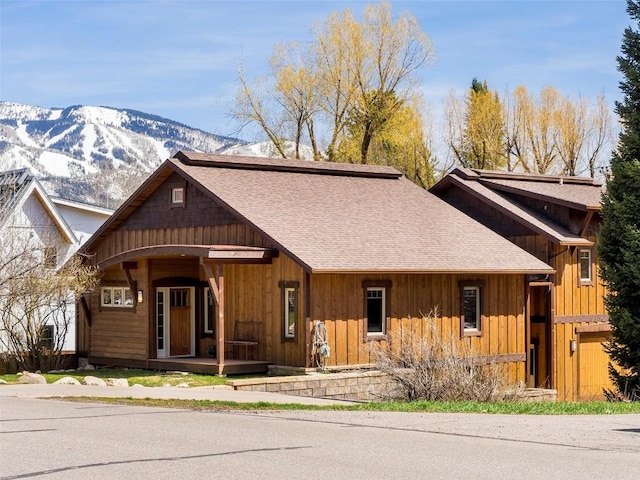 view of front of property featuring a mountain view, covered porch, and a garage