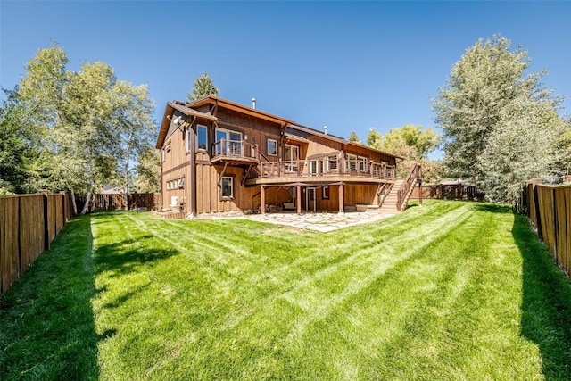 rear view of property featuring a wooden deck and a lawn