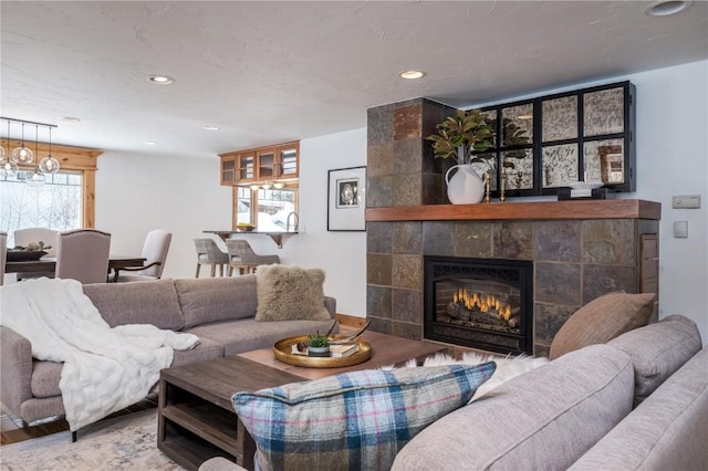 living room with hardwood / wood-style floors and a tiled fireplace