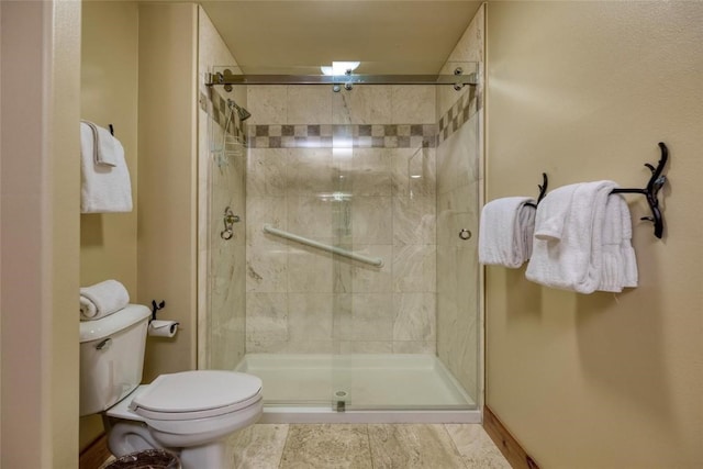 bathroom featuring toilet and a shower with shower door