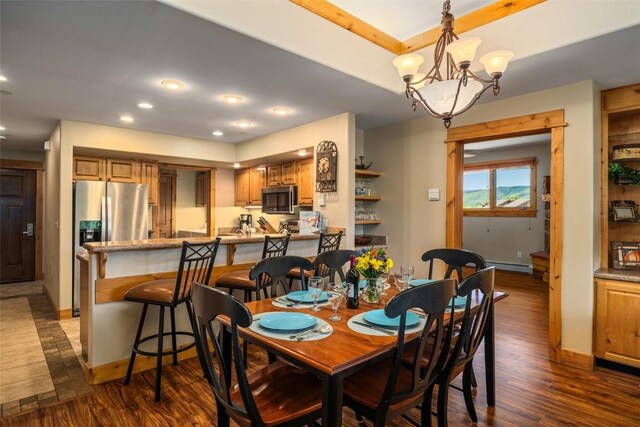 kitchen featuring ceiling fan with notable chandelier, stainless steel appliances, sink, kitchen peninsula, and a raised ceiling