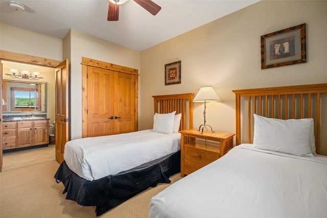 carpeted bedroom featuring a closet, ceiling fan, connected bathroom, and sink