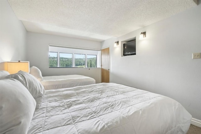 bedroom with carpet floors and a textured ceiling