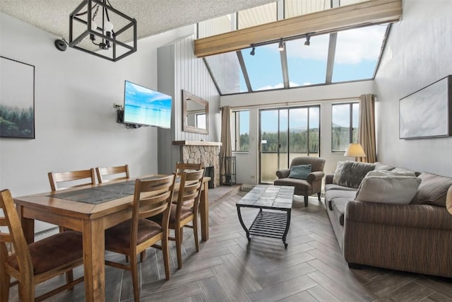 dining area with a fireplace, dark parquet flooring, a notable chandelier, and a high ceiling