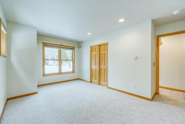 unfurnished bedroom featuring recessed lighting, a closet, baseboards, and carpet flooring