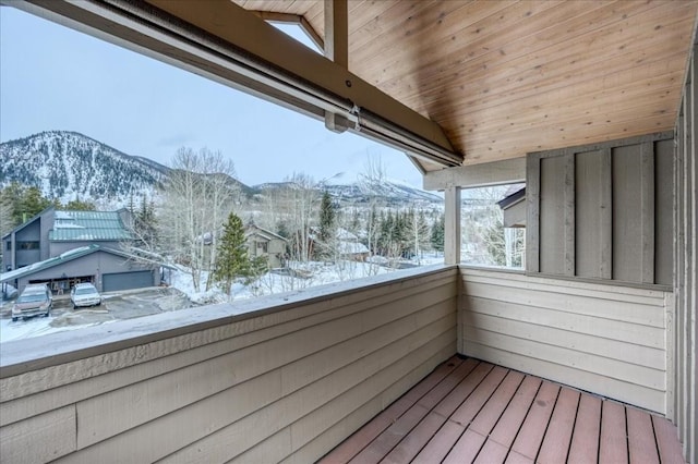 snow covered back of property featuring a mountain view