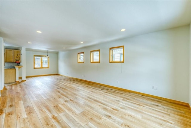 spare room featuring light wood-style flooring, recessed lighting, and baseboards