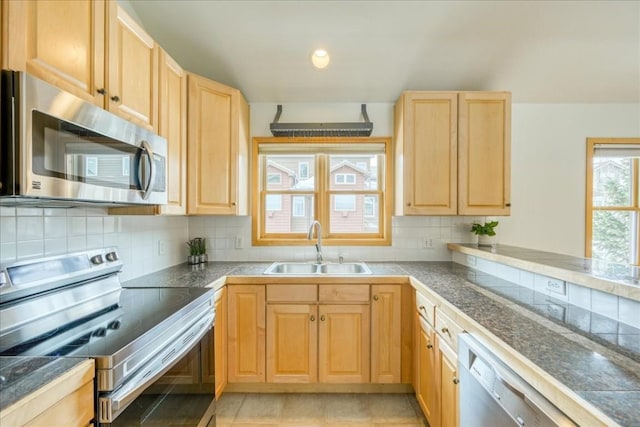 kitchen with a sink, appliances with stainless steel finishes, tile counters, and light brown cabinets