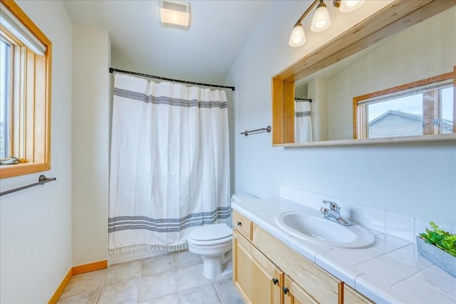 bathroom featuring plenty of natural light, toilet, vanity, and tile patterned flooring