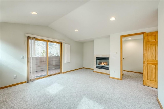 unfurnished living room with baseboards, lofted ceiling, light colored carpet, and a tile fireplace