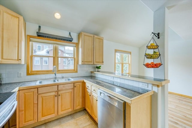 kitchen with dishwasher, a peninsula, light brown cabinetry, and a sink